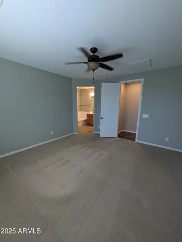 a view of a big room with a ceiling fan and window