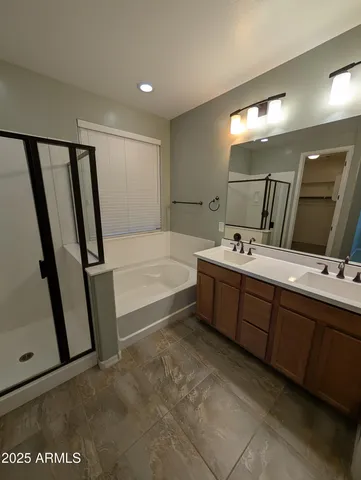 a spacious bathroom with a double vanity sink a mirror and a bathtub