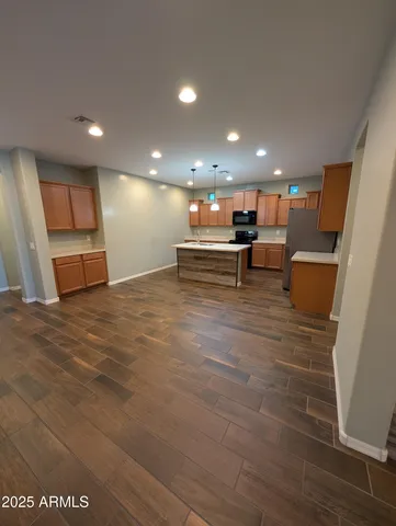 a view of kitchen with granite countertop window and white cabinets