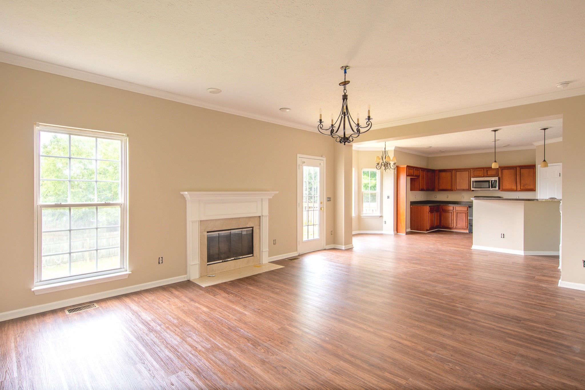 1910 Portway Road Spring Hill, TN 37174 - Photo 8 of 20 an empty room with wooden floor a kitchen view and a window