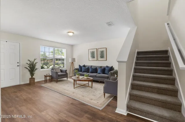 a living room with furniture and a floor to ceiling window