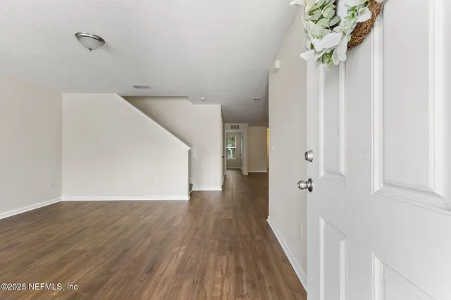 a view of a hallway with wooden floor and staircase