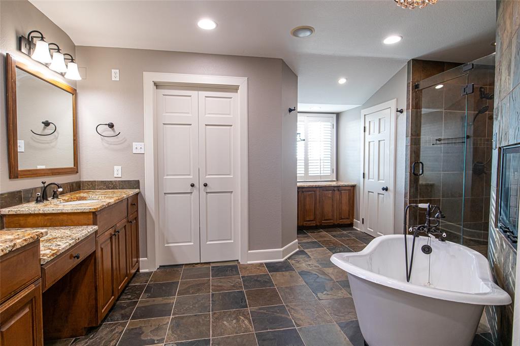 9310 Merritt Road Rowlett, TX 75089 - Photo 14 of 40 a bathroom with a bathtub a sink a toilet a mirror and vanity