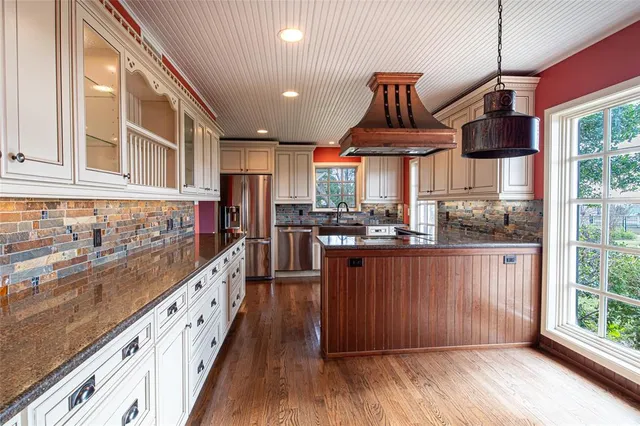 a kitchen with stainless steel appliances granite countertop a stove a sink and a refrigerator