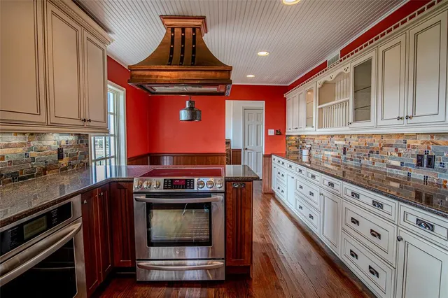 a kitchen with stainless steel appliances granite countertop a stove and cabinets