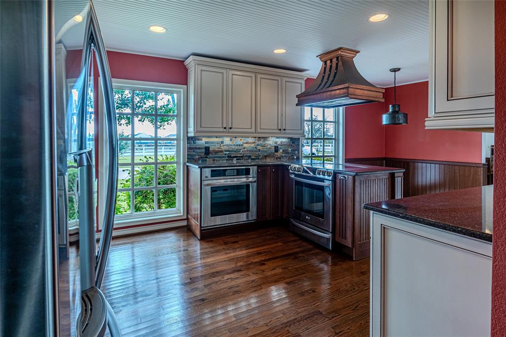 9310 Merritt Road Rowlett, TX 75089 - Photo 6 of 40 a kitchen with kitchen island granite countertop a stove and a wooden floors