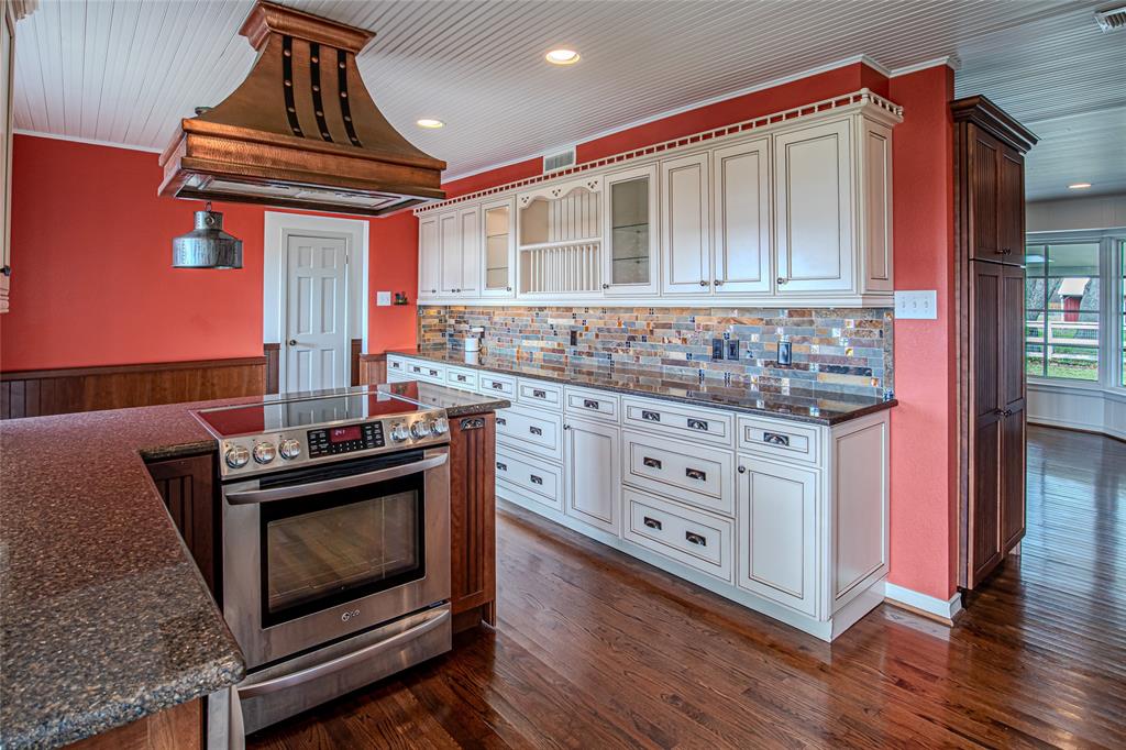 9310 Merritt Road Rowlett, TX 75089 - Photo 7 of 40 a kitchen with stainless steel appliances a stove microwave and cabinets