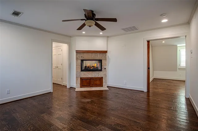 a view of a livingroom with wooden floor a ceiling fan and a ceiling fan