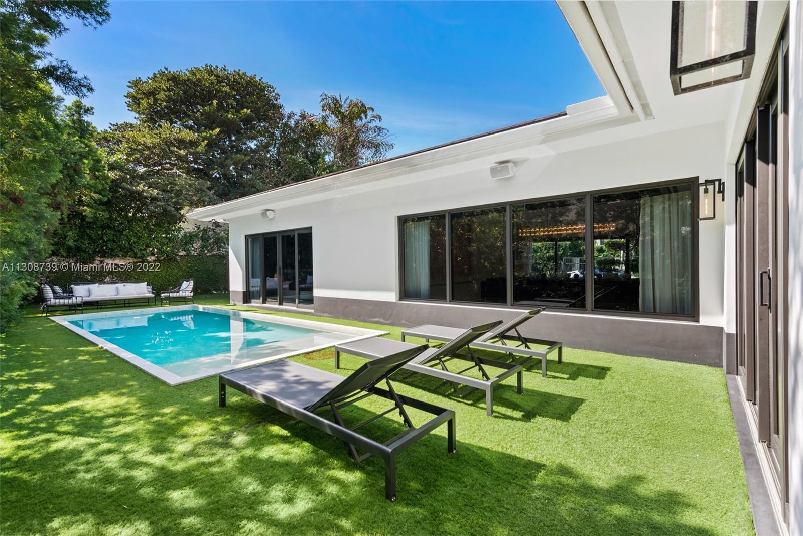 2021 North Bay Road Miami Beach, FL 33140 - Photo 19 of 38 a view of a house with swimming pool and a yard