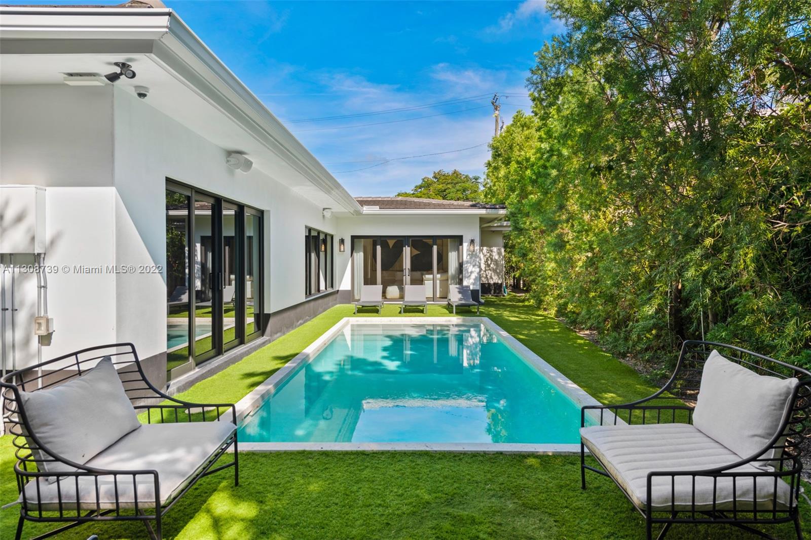 2021 North Bay Road Miami Beach, FL 33140 - Photo 20 of 38 a view of a house with a swimming pool and sitting area