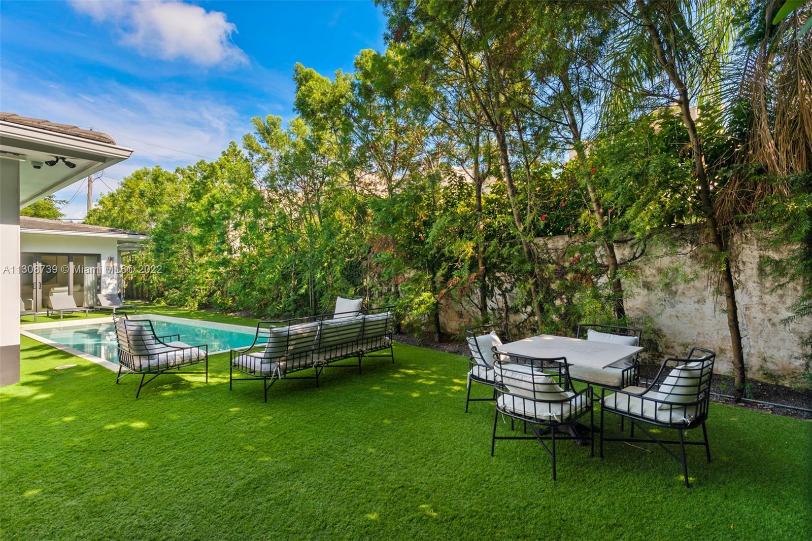 2021 North Bay Road Miami Beach, FL 33140 - Photo 32 of 38 a view of a patio with table and chairs potted plants and large tree