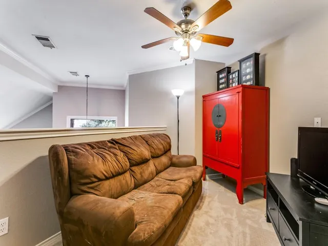 a living room with furniture ceiling fan and a flat screen tv