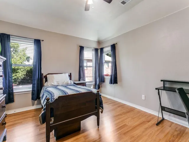 a bedroom with a bed a lamp on dresser and a window