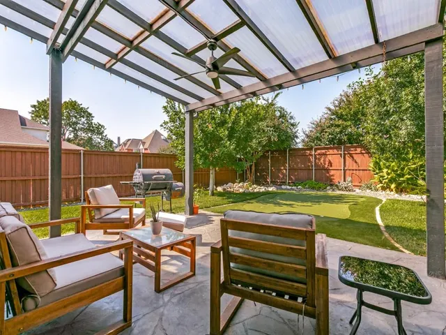 a view of a patio with a table chairs and a backyard