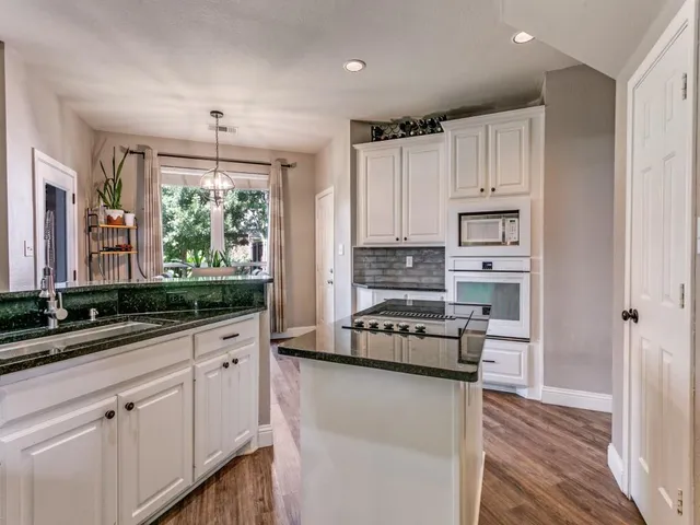 a kitchen with white cabinets and appliances