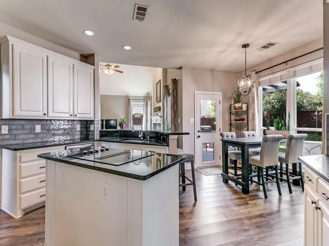 a kitchen with counter space sink stove and wooden floor