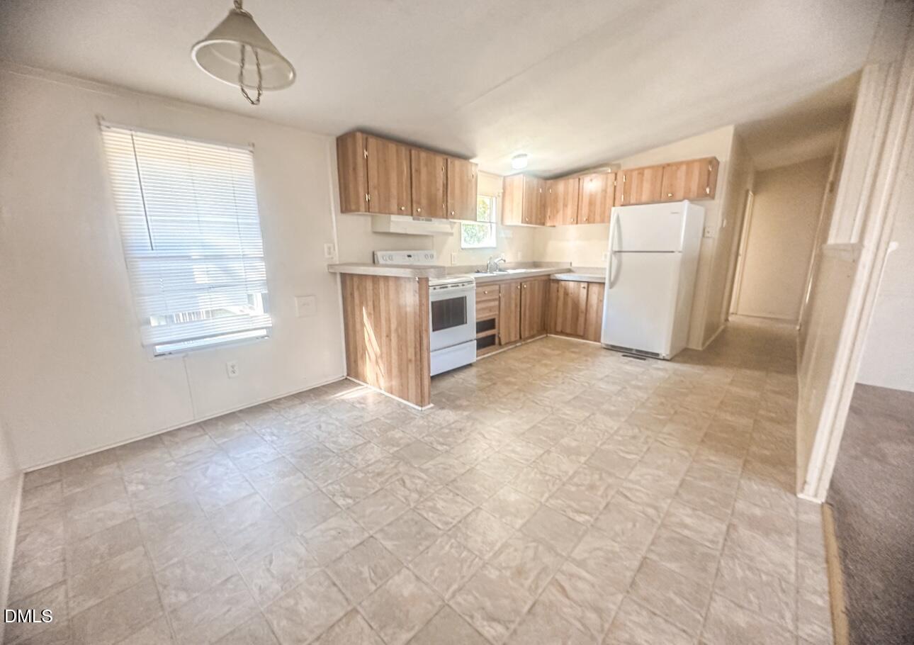 7537 Sam Young Road Oxford, NC 27565 - Photo 13 of 28 a view of kitchen with granite countertop cabinets and refrigerator