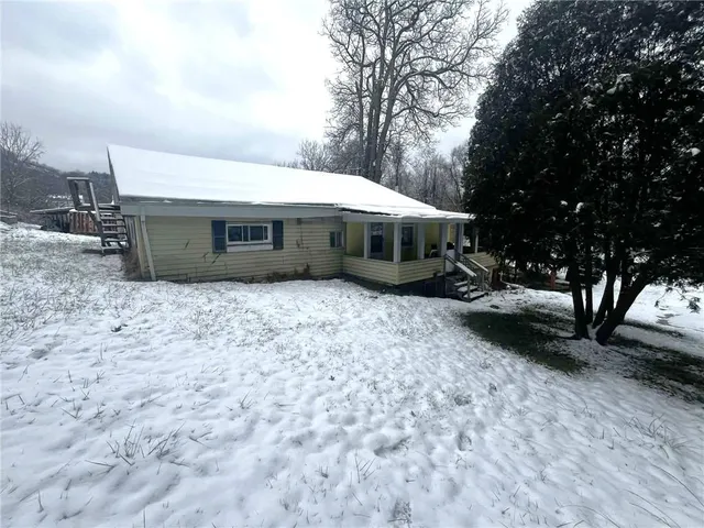 a view of a house with a yard covered in the forest