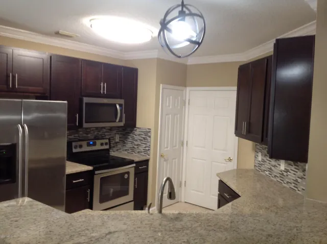 a kitchen with stainless steel appliances granite countertop a refrigerator and a sink