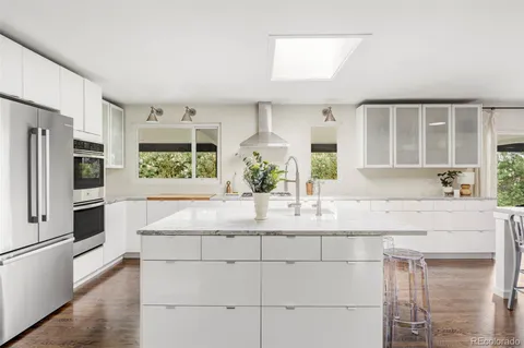 a kitchen with kitchen island granite countertop a refrigerator and a sink