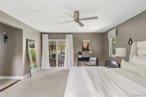 a spacious bedroom with a large bed and a chandelier
