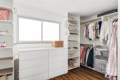a view of walk in closet with clothes and shoes