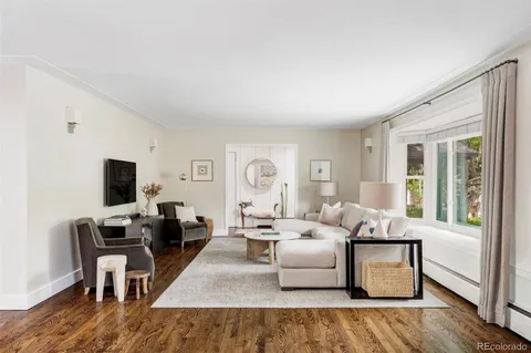 a living room with furniture wooden floor and a flat screen tv