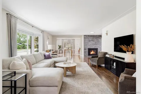 a living room with furniture a flat screen tv and a fireplace