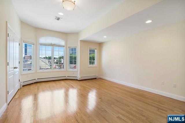 212 Slocum Way, Unit A Fort Lee, NJ 07024 - Photo 16 of 30 a view of an empty room with a window and wooden floor