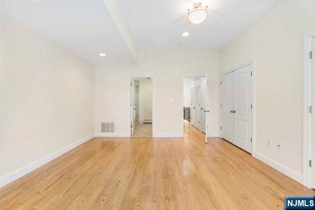 212 Slocum Way, Unit A Fort Lee, NJ 07024 - Photo 17 of 30 a view of an empty room with wooden floor and a window