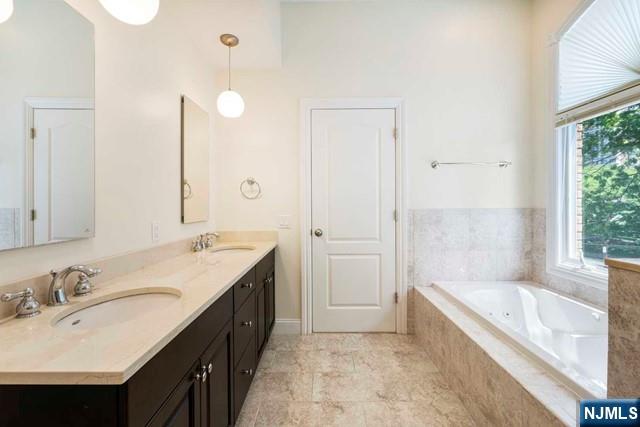 212 Slocum Way, Unit A Fort Lee, NJ 07024 - Photo 19 of 30 a spacious bathroom with a bathtub sink and mirror