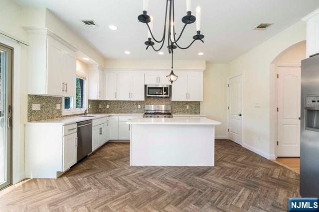 212 Slocum Way, Unit A Fort Lee, NJ 07024 - Photo 5 of 30 a kitchen with stainless steel appliances granite countertop a sink a stove a refrigerator and white cabinets