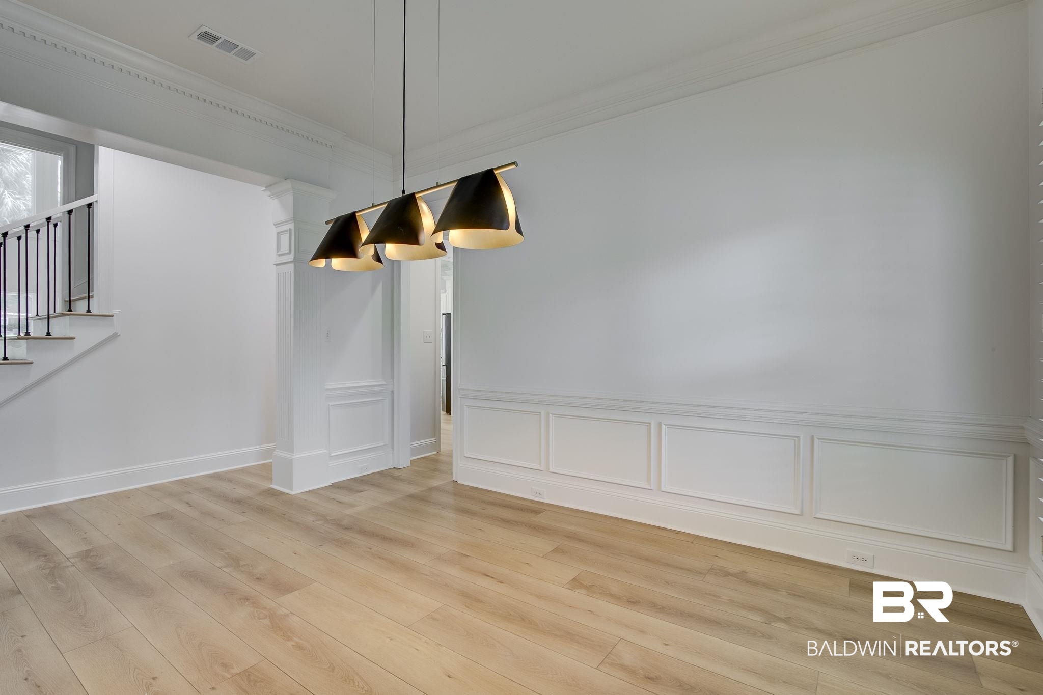 105 High Pines Ridge Fairhope, AL 36532 - Photo 38 of 97 Unfurnished dining area with crown molding, a decorative wall, light wood-style flooring, stairway, and wainscoting