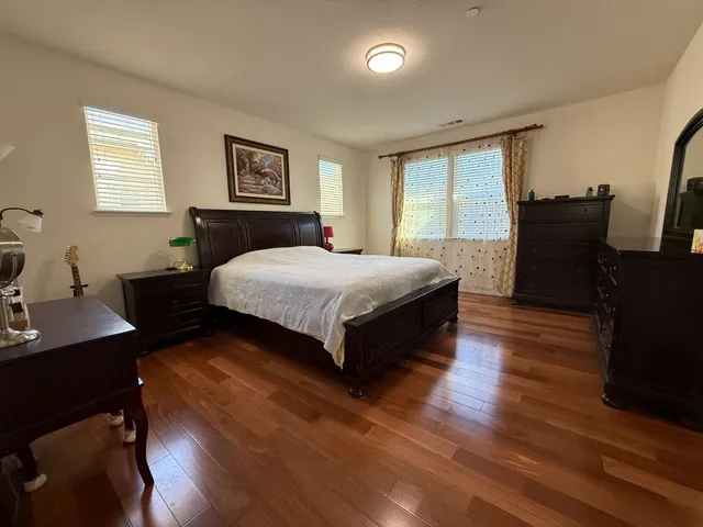 a bedroom with a bed and wooden floor