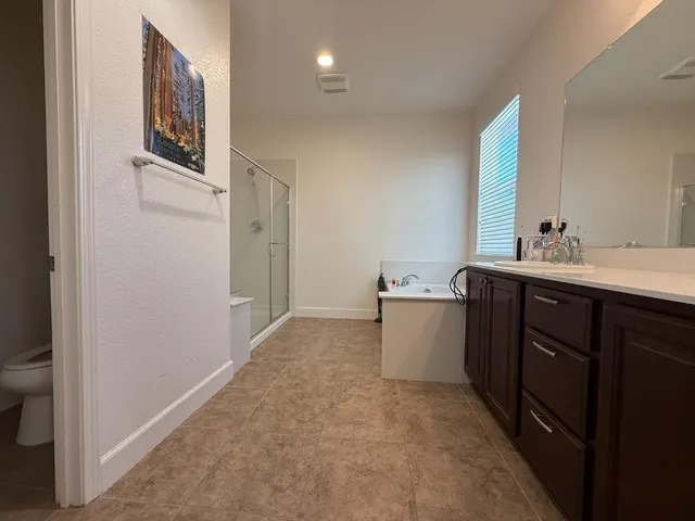 a bedroom with a bed table chair and a window