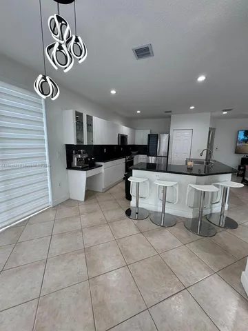 a kitchen with stainless steel appliances kitchen island granite countertop a sink and cabinets