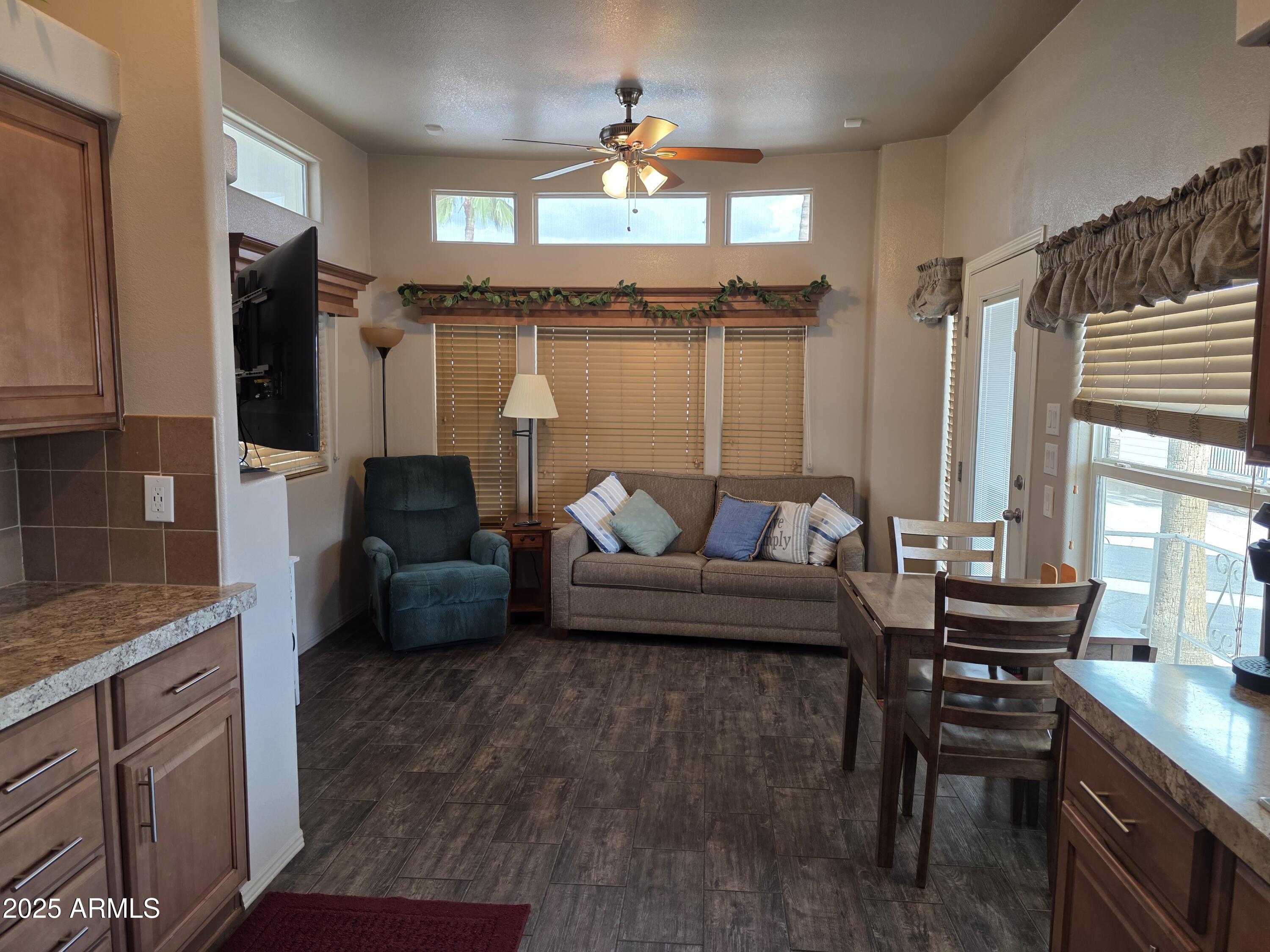 1457 South Zuni Avenue, Unit 457 Apache Junction, AZ 85119 - Photo 6 of 12 a living room with furniture a fireplace and a flat screen tv