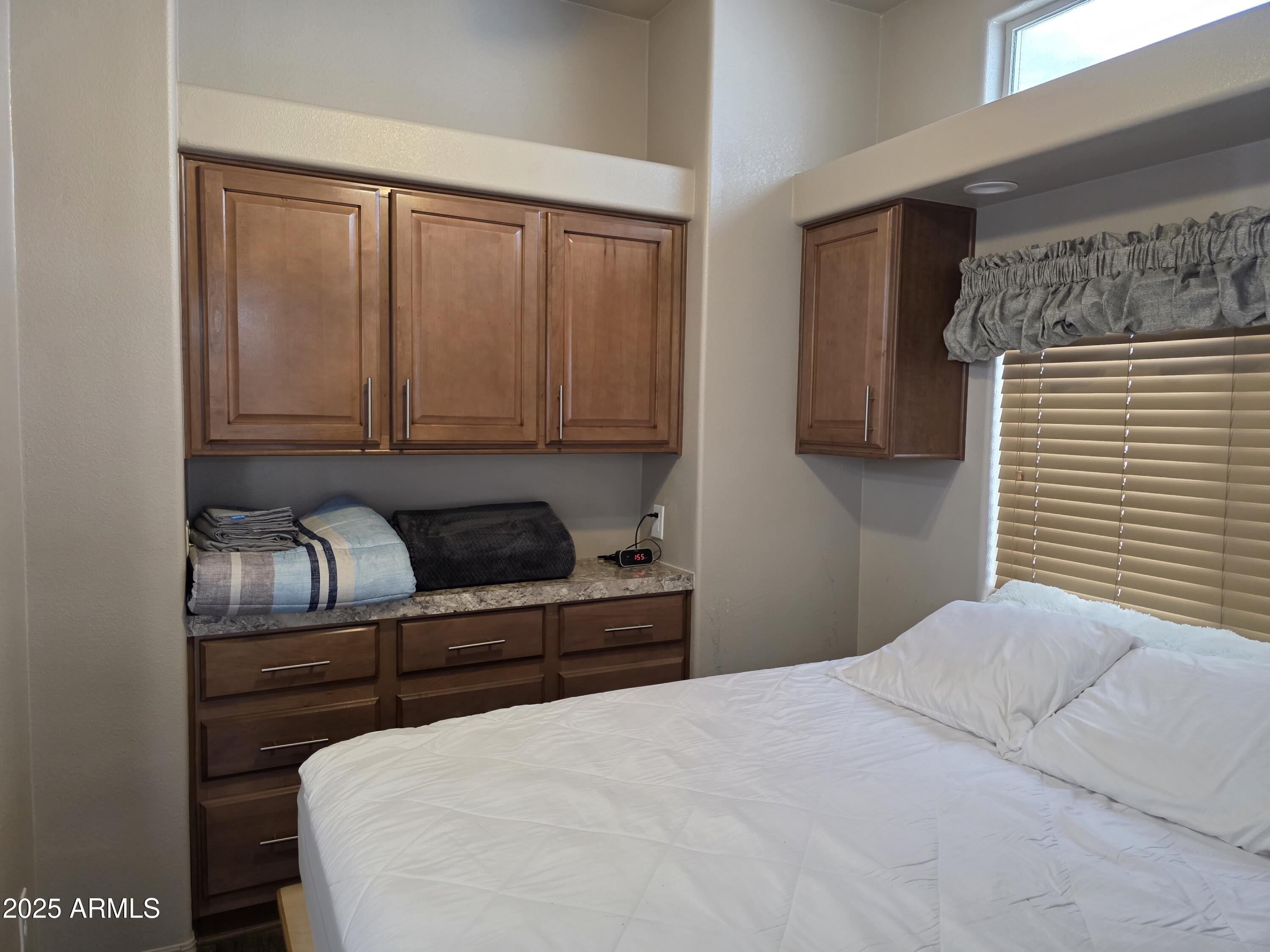 1457 South Zuni Avenue, Unit 457 Apache Junction, AZ 85119 - Photo 10 of 12 a bedroom with a bed and wooden floor