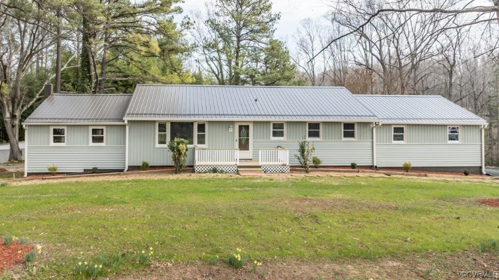 a front view of a house with a garden and trees