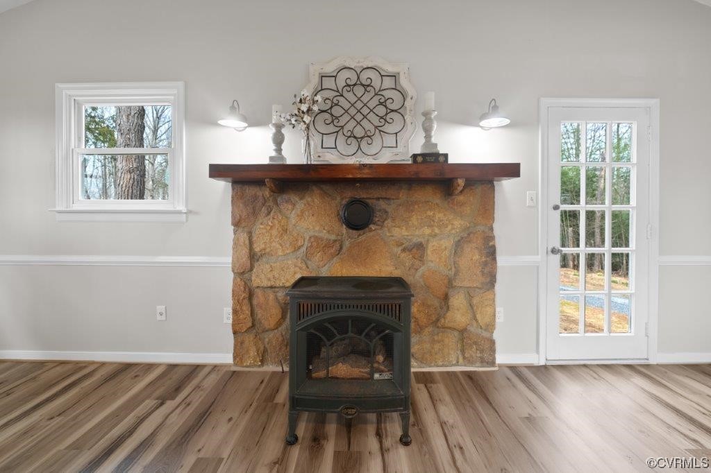 134 Ampthill Road Cartersville, VA 23027 - Photo 25 of 50 an empty room with wooden floor a fireplace and windows