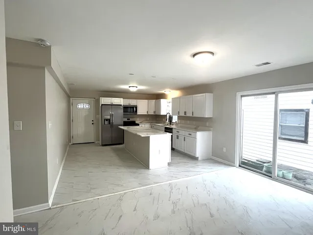 a view of a kitchen with a sink and a refrigerator