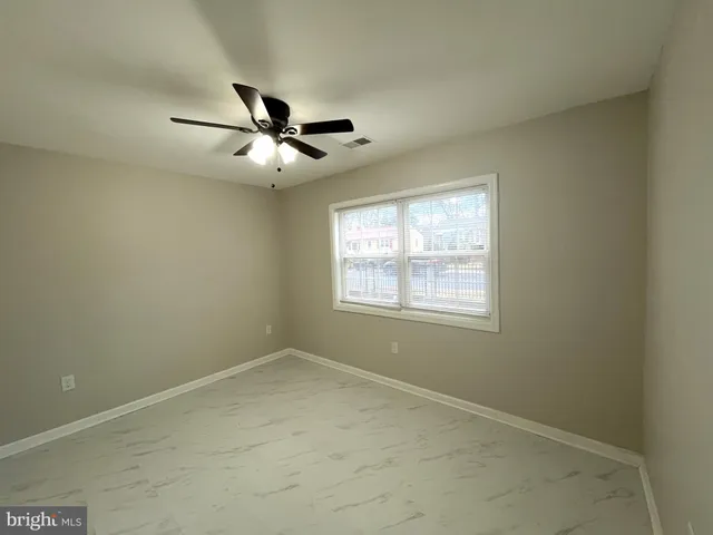 an empty room with a window and a fan