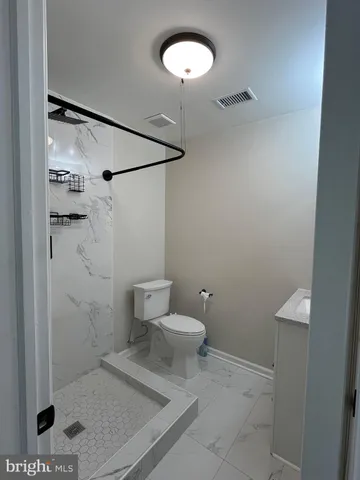 a bathroom with a toilet and a shower