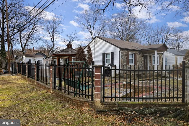 a view of a white house with large windows and a small yard