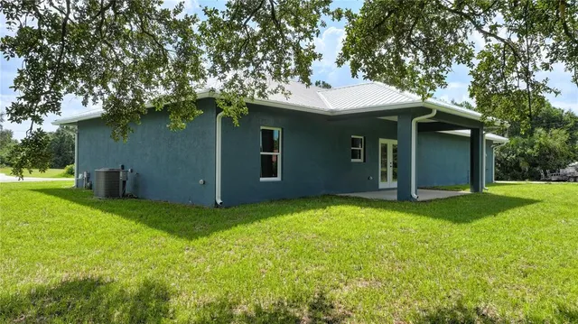 a view of a house with a yard and tree