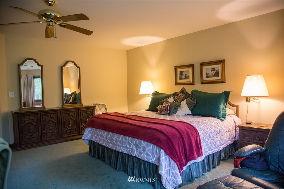 22705 Peter Grubb Road Southeast Renton, WA 98058 - Photo 14 of 40 a bedroom with a bed and dresser with mirror