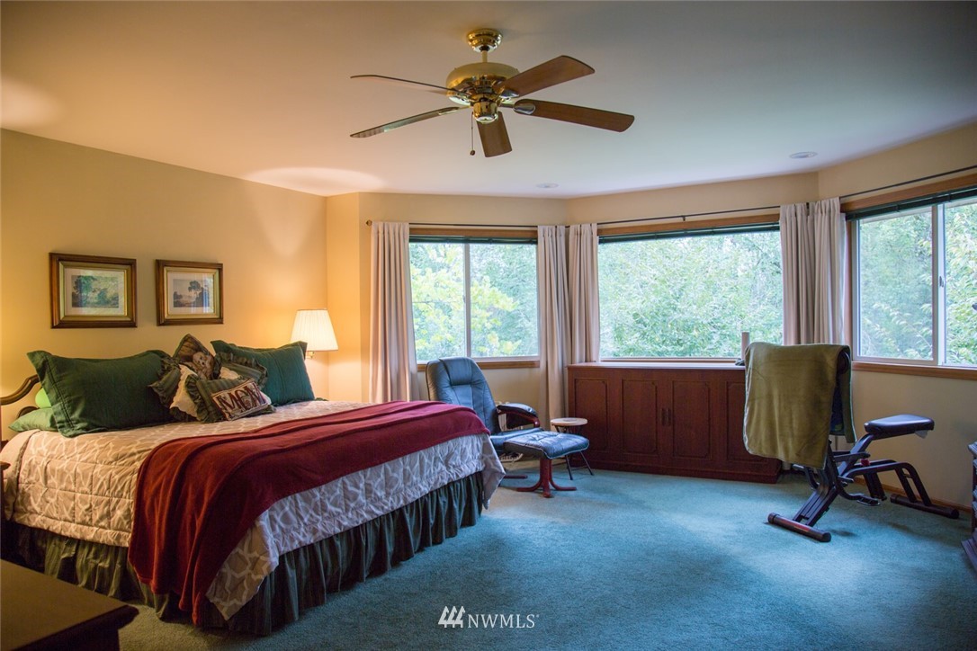 22705 Peter Grubb Road Southeast Renton, WA 98058 - Photo 15 of 40 a bedroom with a bed a table and a chandelier