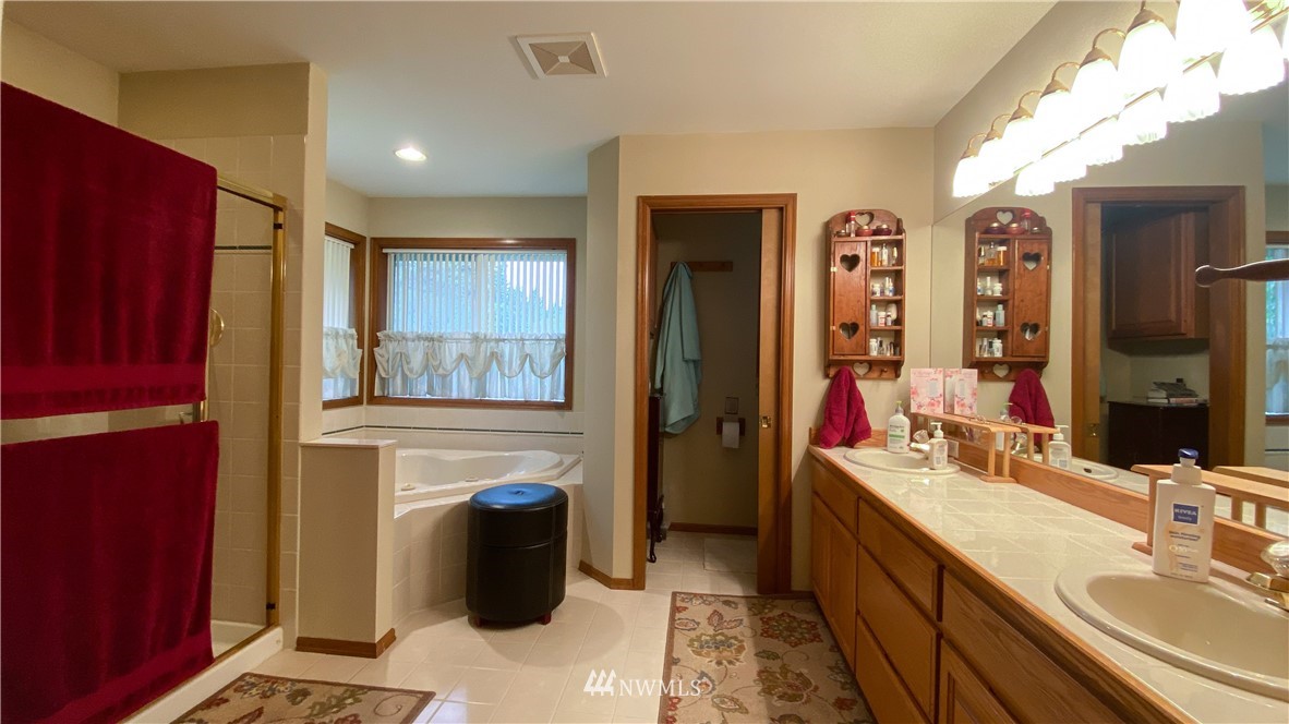 22705 Peter Grubb Road Southeast Renton, WA 98058 - Photo 16 of 40 a bathroom with a sink a mirror and a bathtub