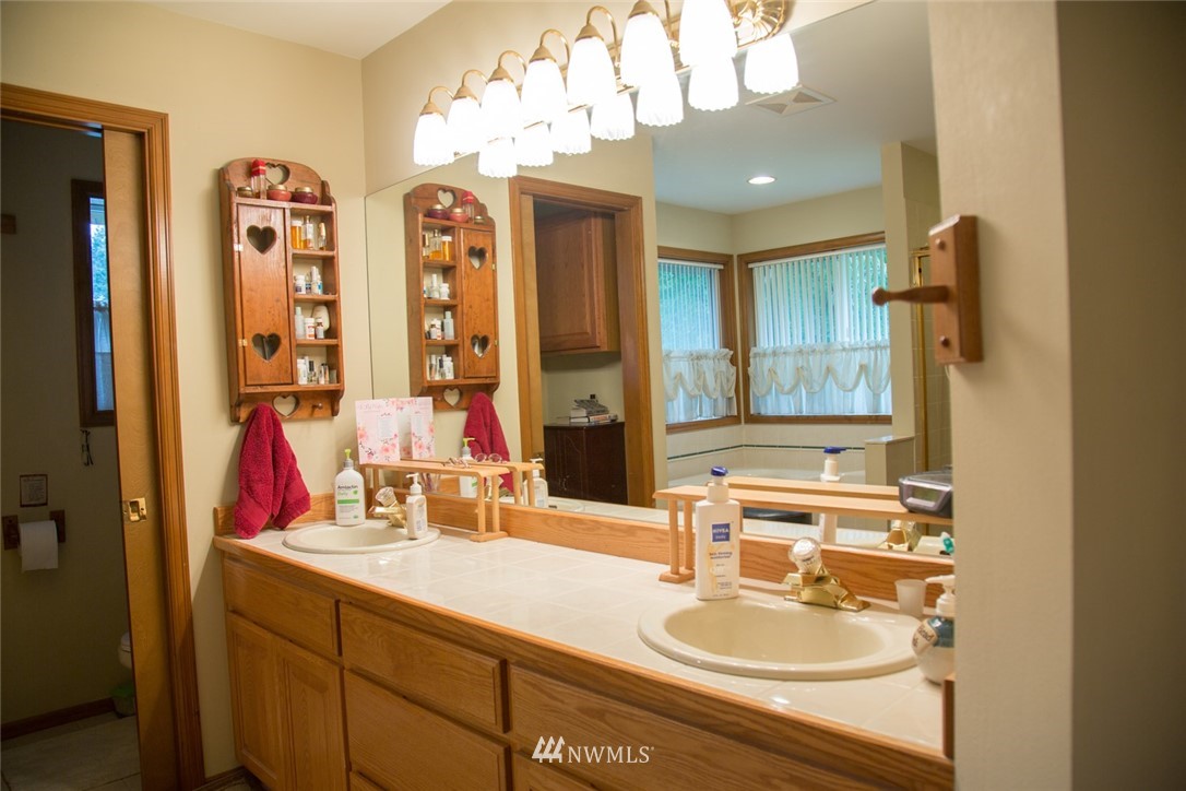 22705 Peter Grubb Road Southeast Renton, WA 98058 - Photo 18 of 40 a bathroom with a sink double vanity granite and a mirror