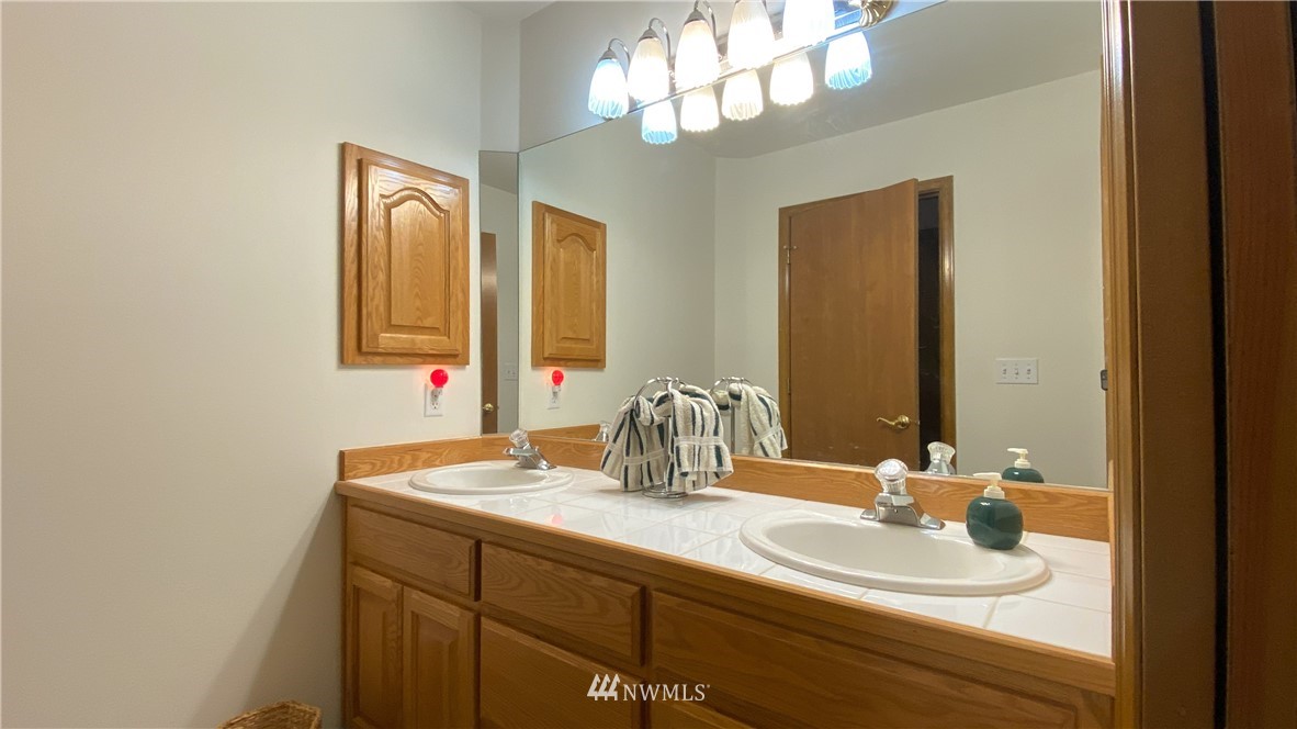 22705 Peter Grubb Road Southeast Renton, WA 98058 - Photo 24 of 40 a bathroom with a double vanity sink and a mirror
